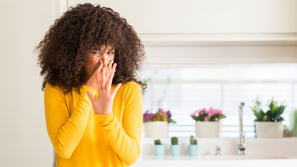 Women smelling something bad in a kitchen