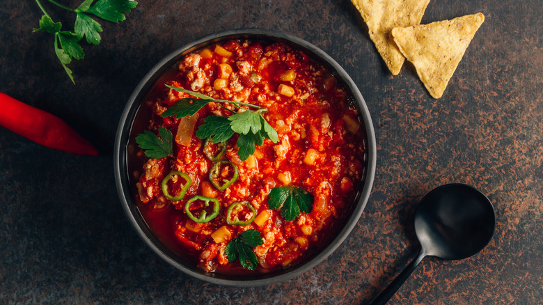 A bowl of chili with chips