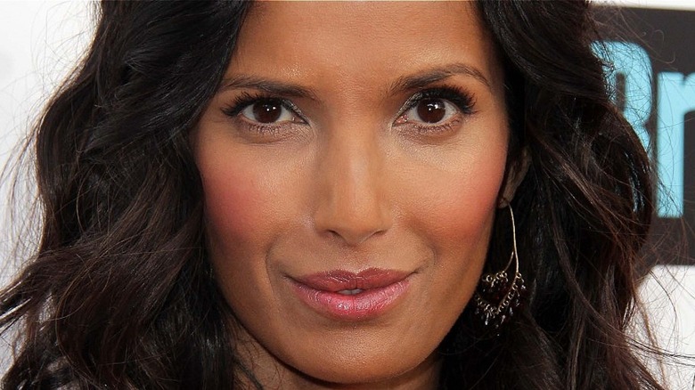 Padma Lakshmi smiles with pink lips