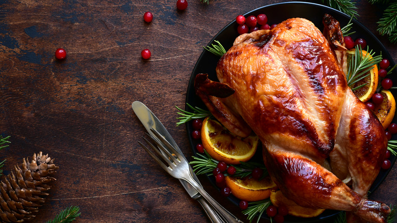 roasted chicken near cranberries and pinecones