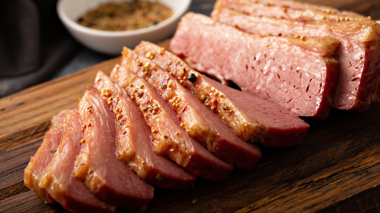 sliced corned beef on wooden board