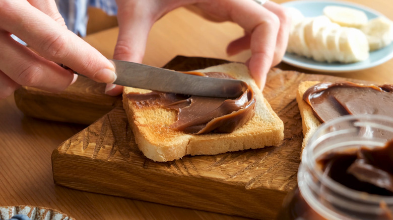 Person spreading Nutella on toast