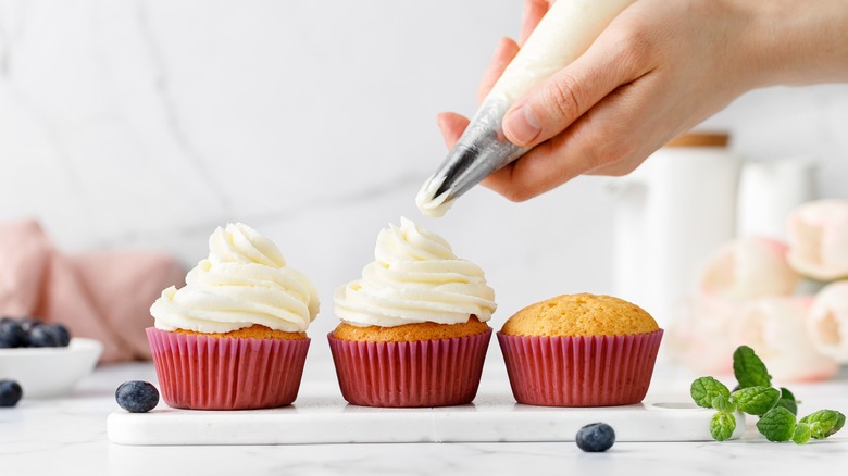 Piping frosting on a cupcake