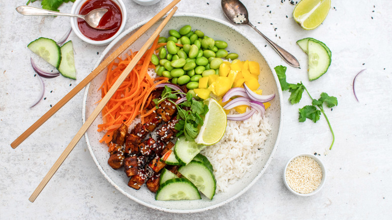 sriracha tofu coconut rice bowl with chopsticks