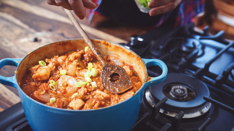 stirring gumbo in blue pot