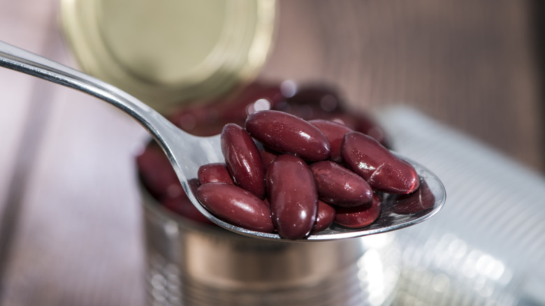 kidney beans in open can with spoon