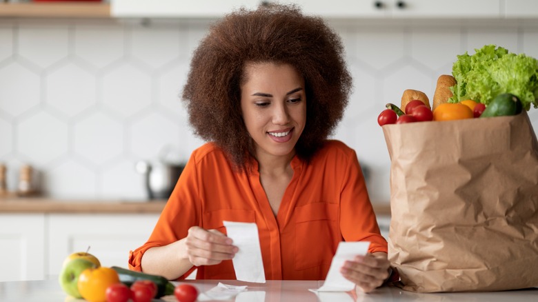 woman checking grocery receipts