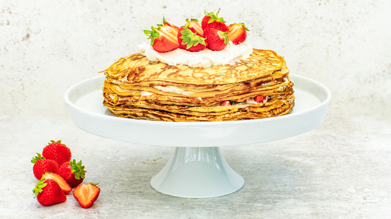 strawberries and cream crepe cake on stand