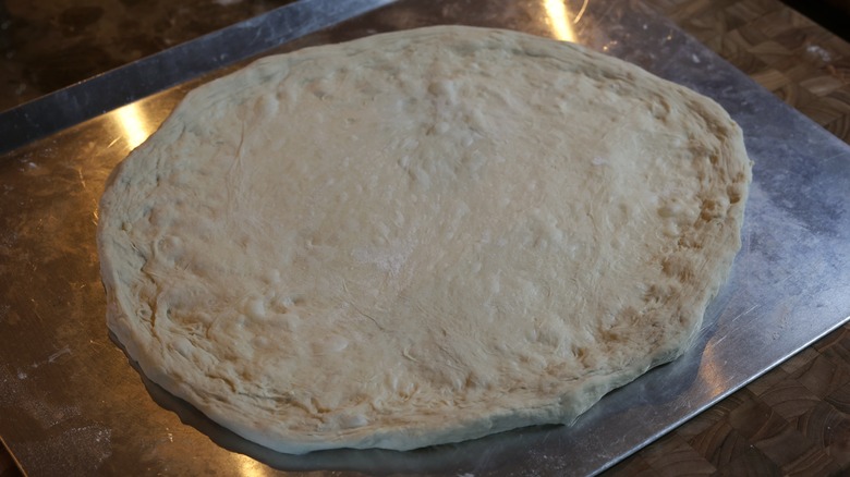 pizza dough on baking sheet