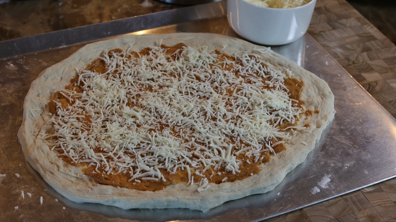 pizza dough with sauce and cheese