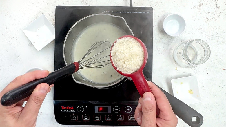 adding parmesan cheese to white sauce