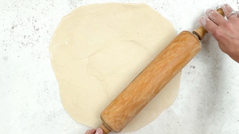 rolling out pizza dough