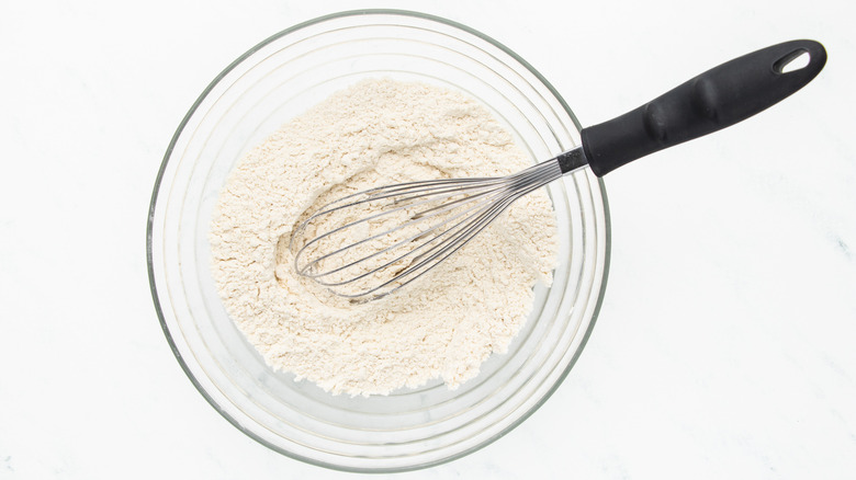 whisking dry muffin ingredients in bowl