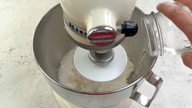 adding water to pizza dough