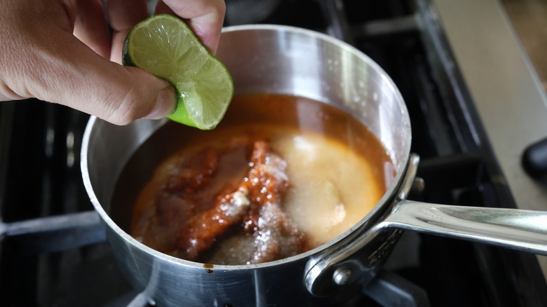 squeezing lime into saucepan