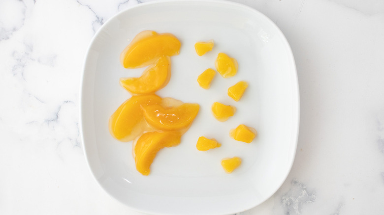 canned peaches on white plate