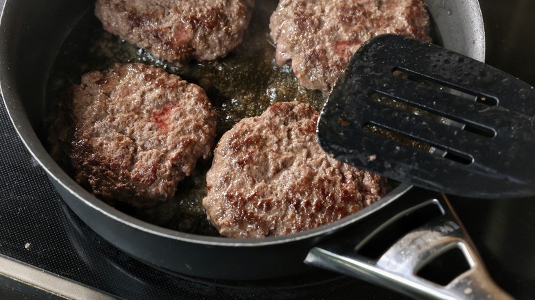 burgers cooking in skillet