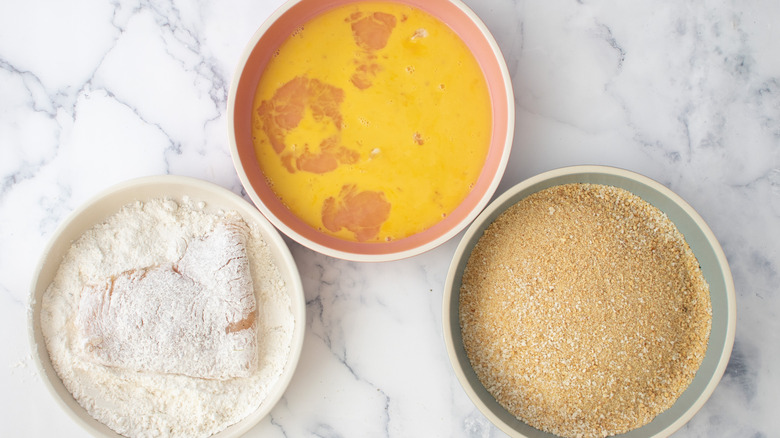 chicken cutlet in flour bowl