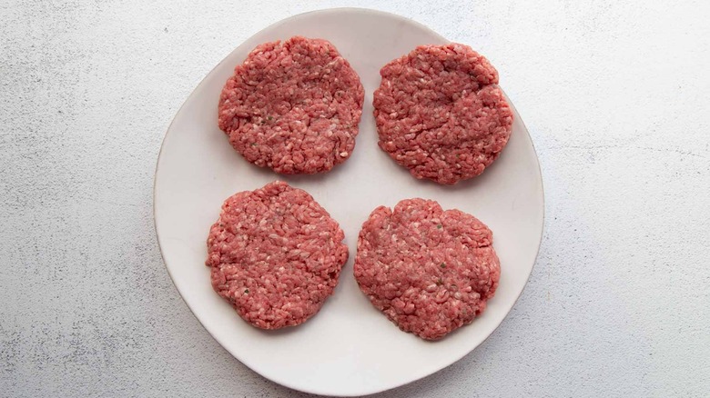 four burger patties on plate