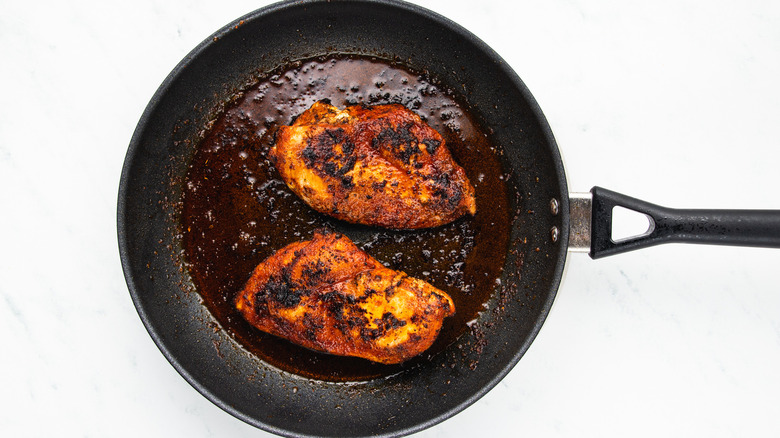 blackened chicken breasts in frying pan