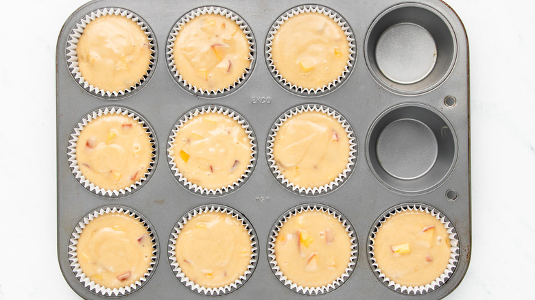 peach muffin batter in muffin tin