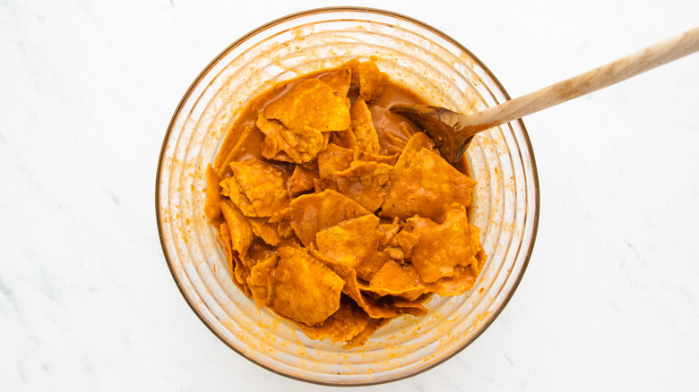 sauce-coated tortilla chips in mixing bowl