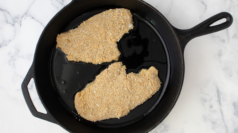 breaded chicken cutlets in skillet