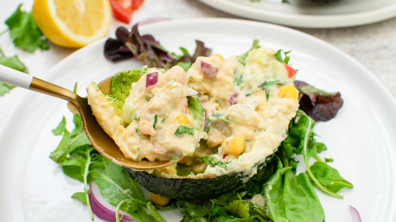 smashed chickpea stuffed avocado with spoon