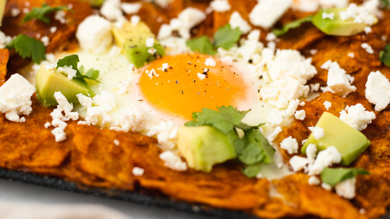 close up of chilaquiles rojos with egg